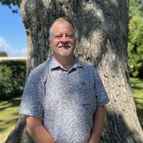 Mark Hedrick stands in front of a tree